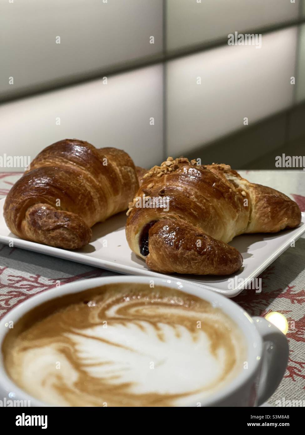 Petit-déjeuner italien typique avec un cappuccino et deux croissants au bar Banque D'Images