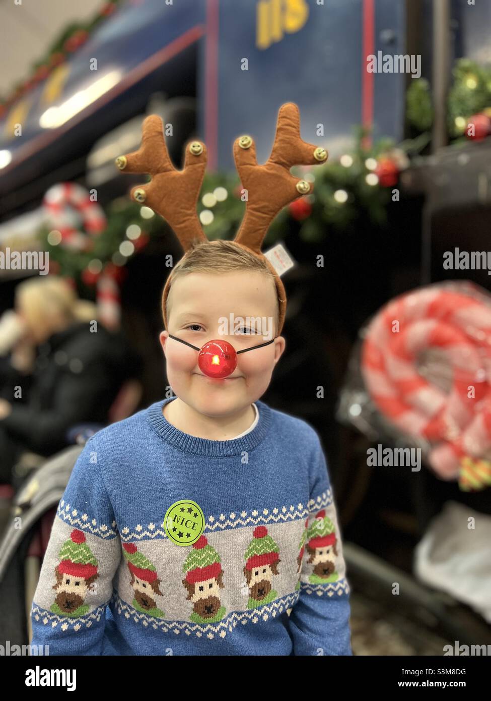 Jeune garçon en pull de Noël et nez rouge éclatant Banque D'Images