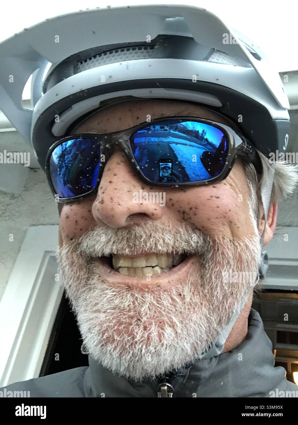 Visage boueux d'un motard de montagne portant un casque et des lunettes de soleil Banque D'Images