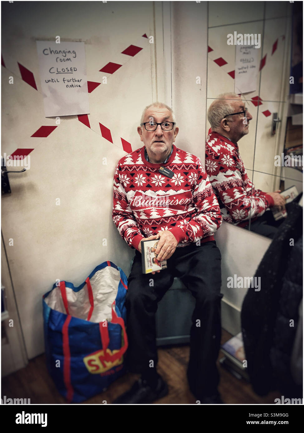 Un bénévole de la boutique caritative dans un pull de Noël Banque D'Images