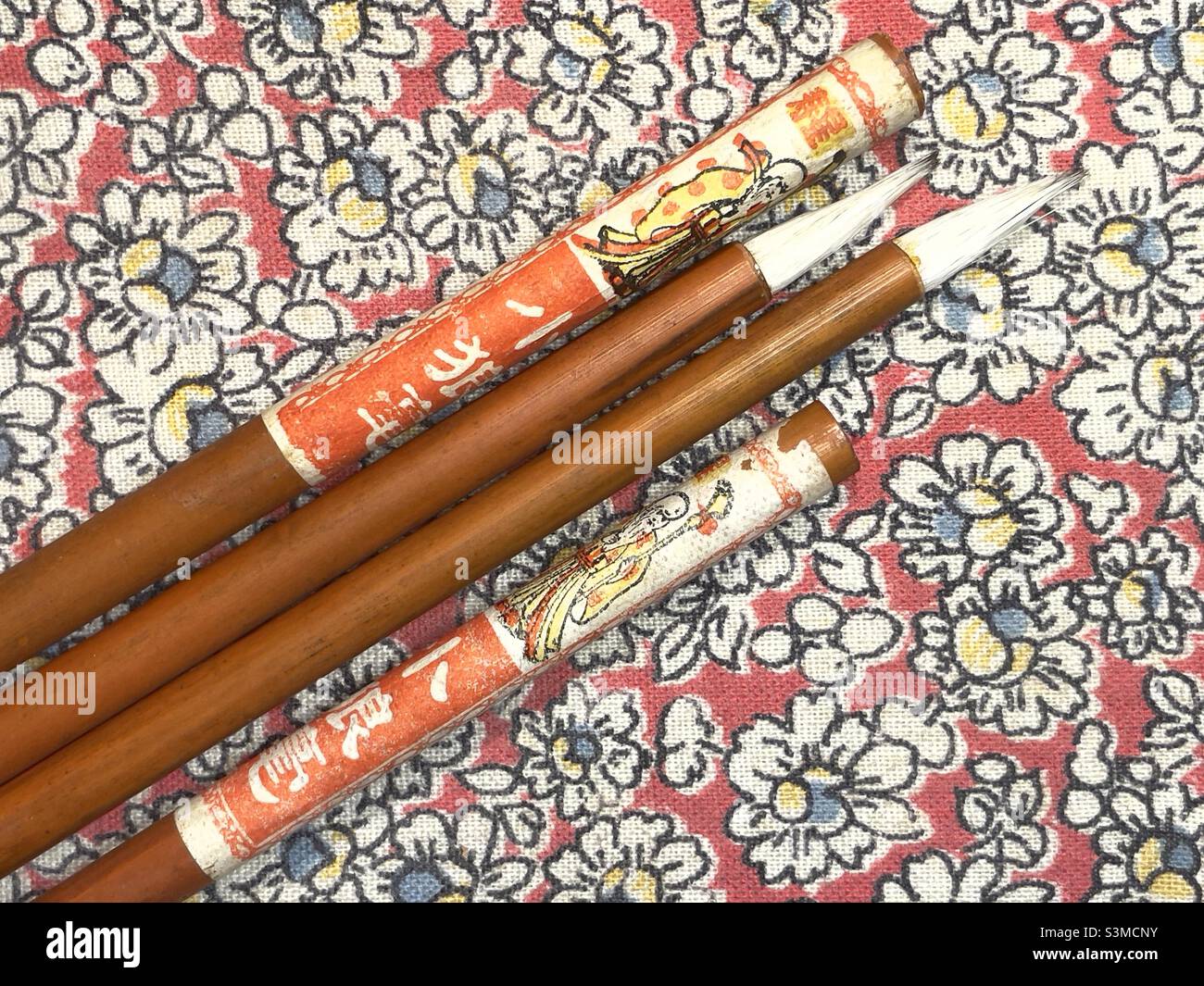 Quatre pinceaux d'écriture chinois reposant sur le couvercle de leur boîte - Image de stock capturée avec un smartphone