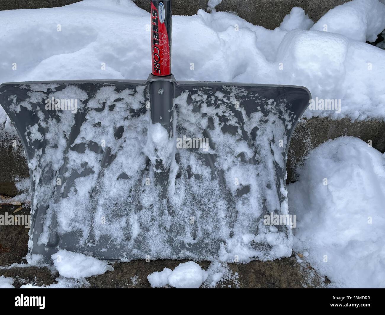 Un pied de neige a nécessité l'utilisation de cette pelle à neige robuste dans l'Utah, aux États-Unis.La pelle enneigée est soutenue contre des marches de porche couvertes de neige pour rendre cette saison encore vie. Banque D'Images