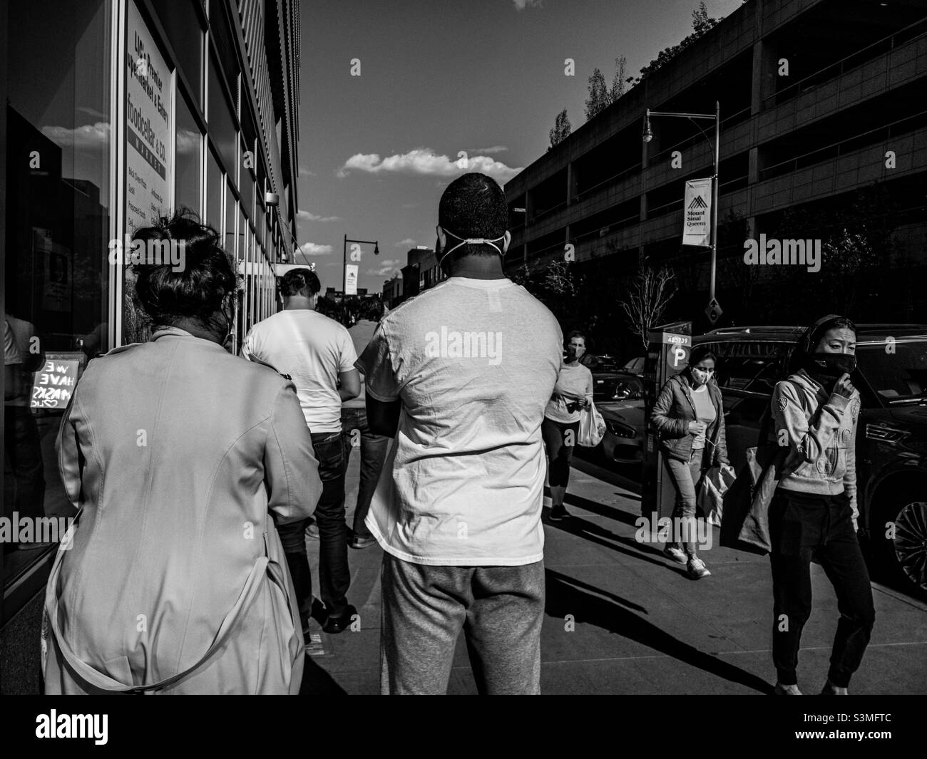 Les gens qui font la queue pour se rendre dans l'épicerie fine Food Cellar à long Island City, New York, en raison de la réduction des restrictions d'occupation pendant les premiers jours de la pandémie Covid 19 Banque D'Images