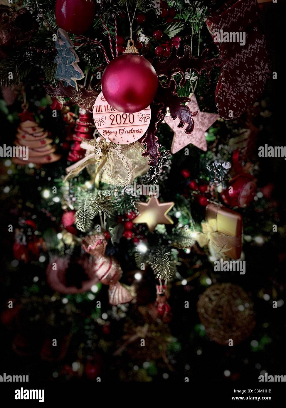 Gros plan d'un éclairage spectaculaire sur un arbre de Noël britannique traditionnel décoré de breloques de bonbons et de fruits Banque D'Images