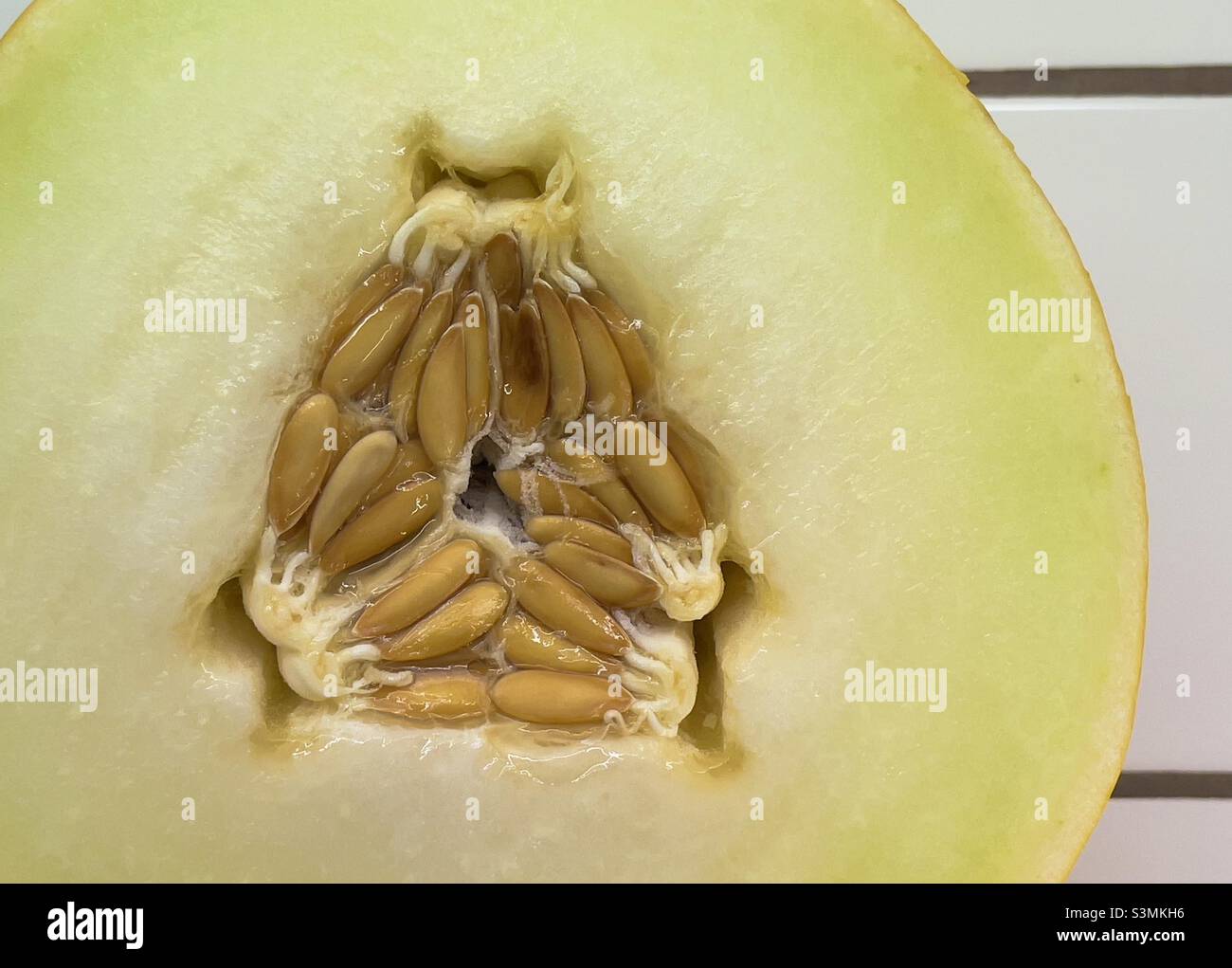 Un gros plan de la moitié d'un melon canari montrant les pépins ou les graines au centre Banque D'Images