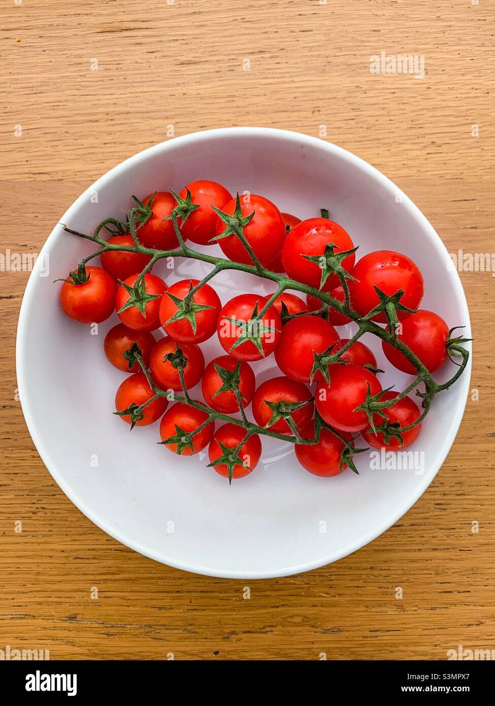 Tomates sur la vigne dans un bol Banque D'Images