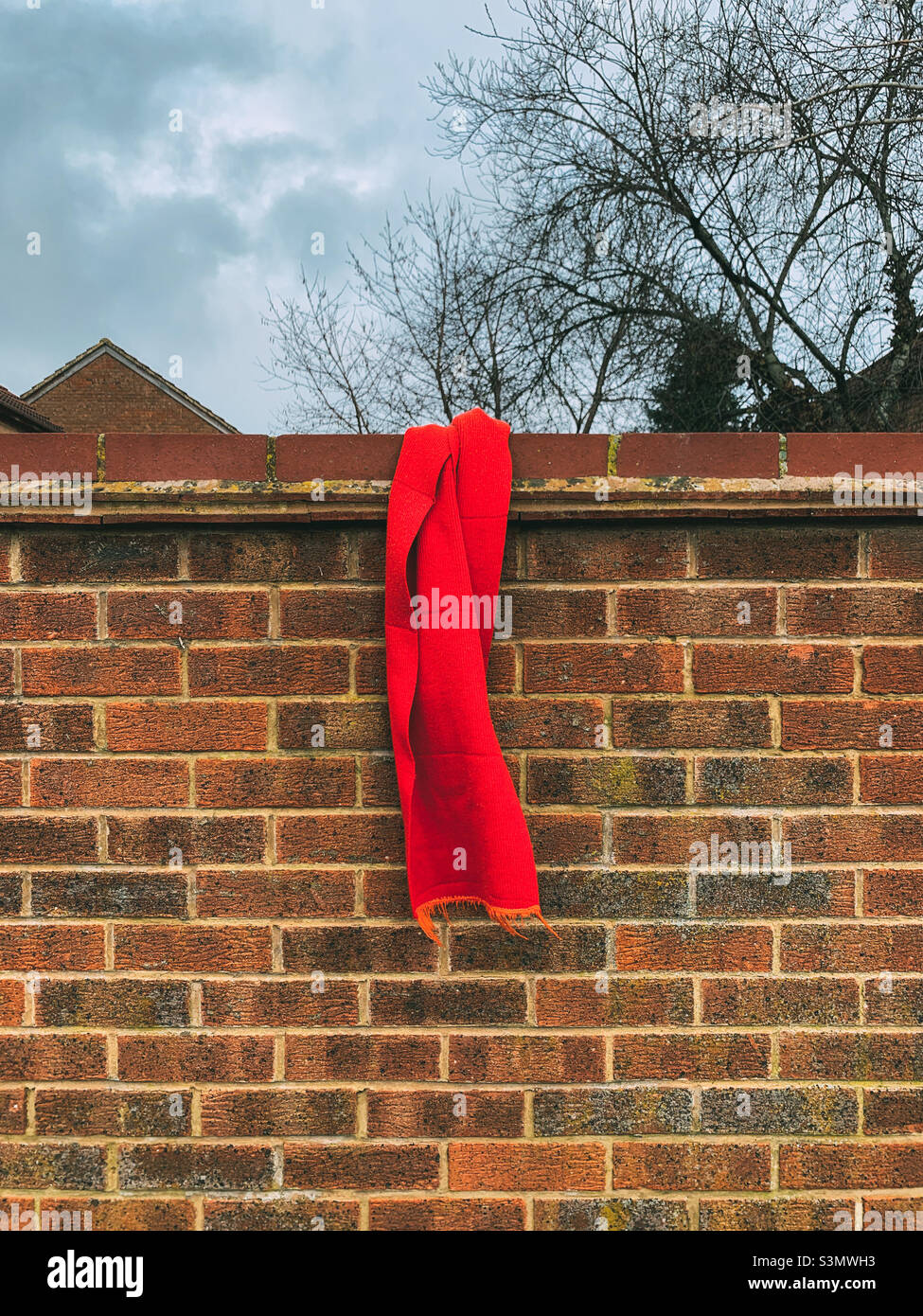 Foulard rouge perdu sur un mur de briques Photo Stock - Alamy