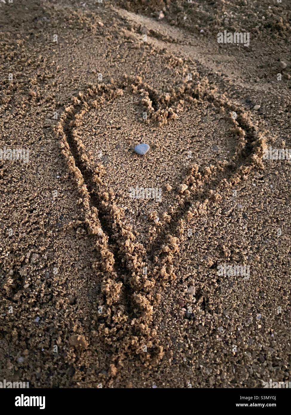 Écrire à la main sur le sable en forme de cœur Banque D'Images