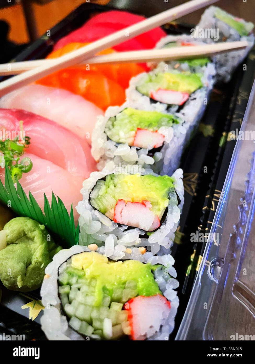 Boîte de livraison de pièces de sushi et rouleau de Californie avec baguettes en bois, 2022, New York City, États-Unis Banque D'Images