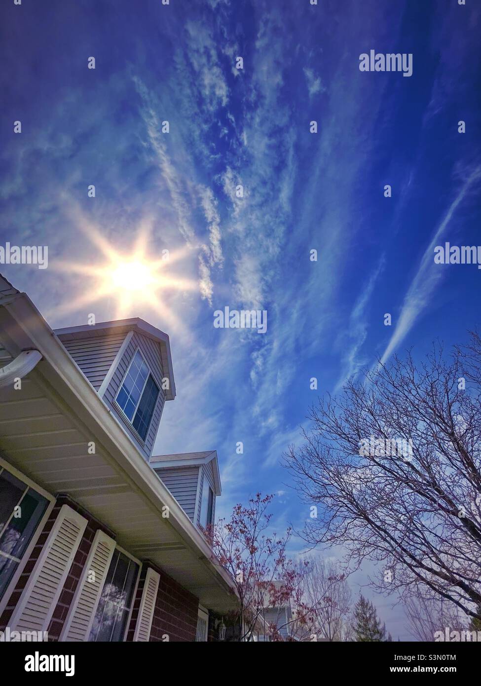 Maison de style Cape Cod, avec le soleil brillant derrière la fenêtre de dormeur, dans l'Utah, États-Unis. - Image de stock capturée avec un smartphone
