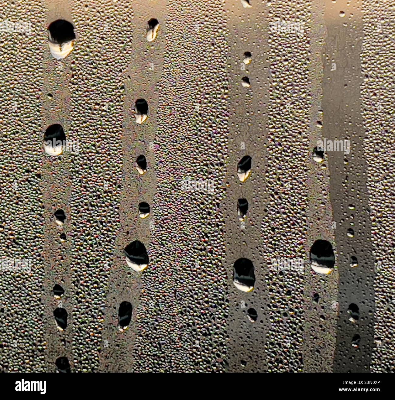 Des gouttelettes d'eau s'écoulent sur une vitre cachée par de la condensation Banque D'Images