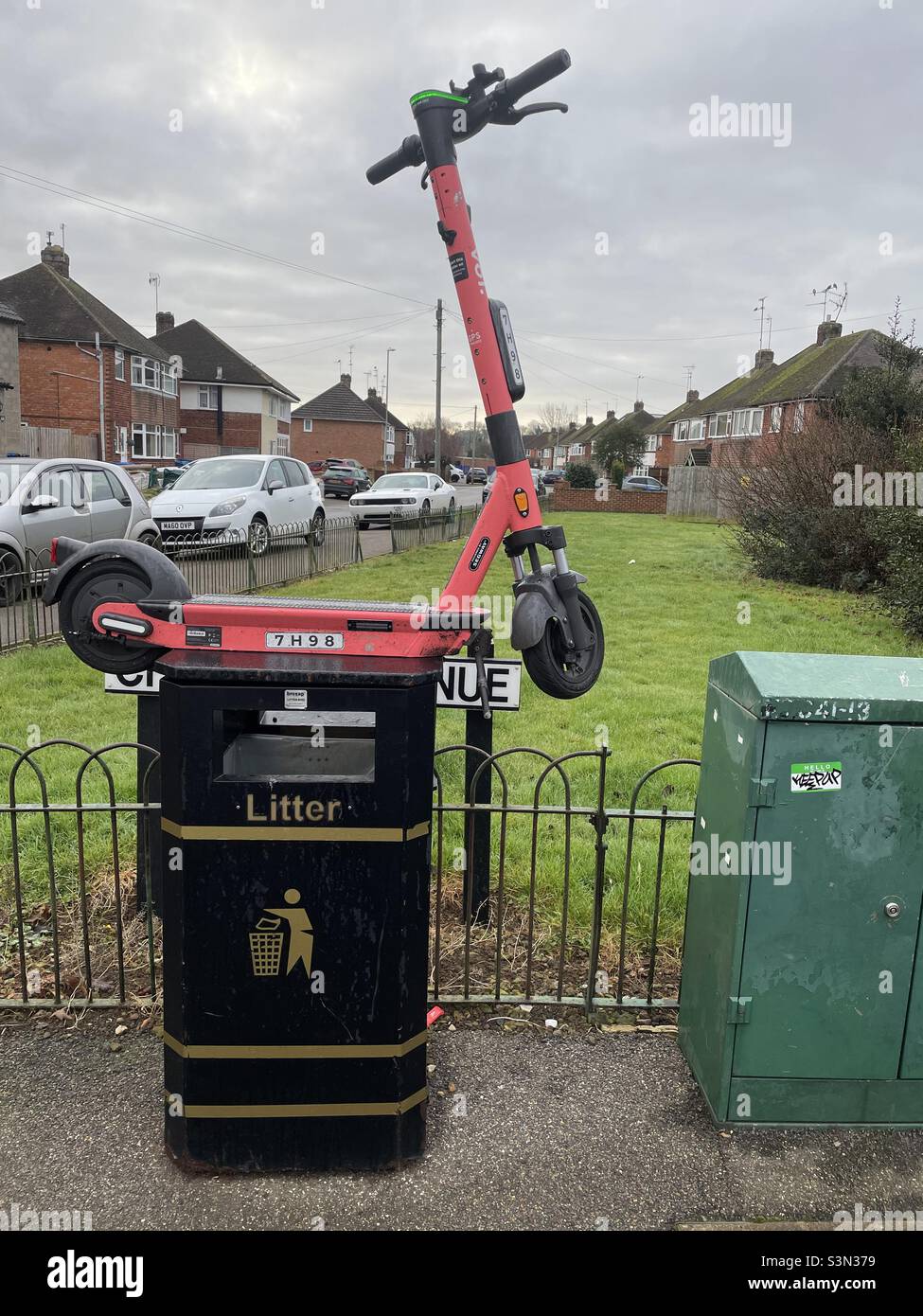 E-Scooter sur le dessus de la poubelle à litière dans la rue résidentielle Banque D'Images