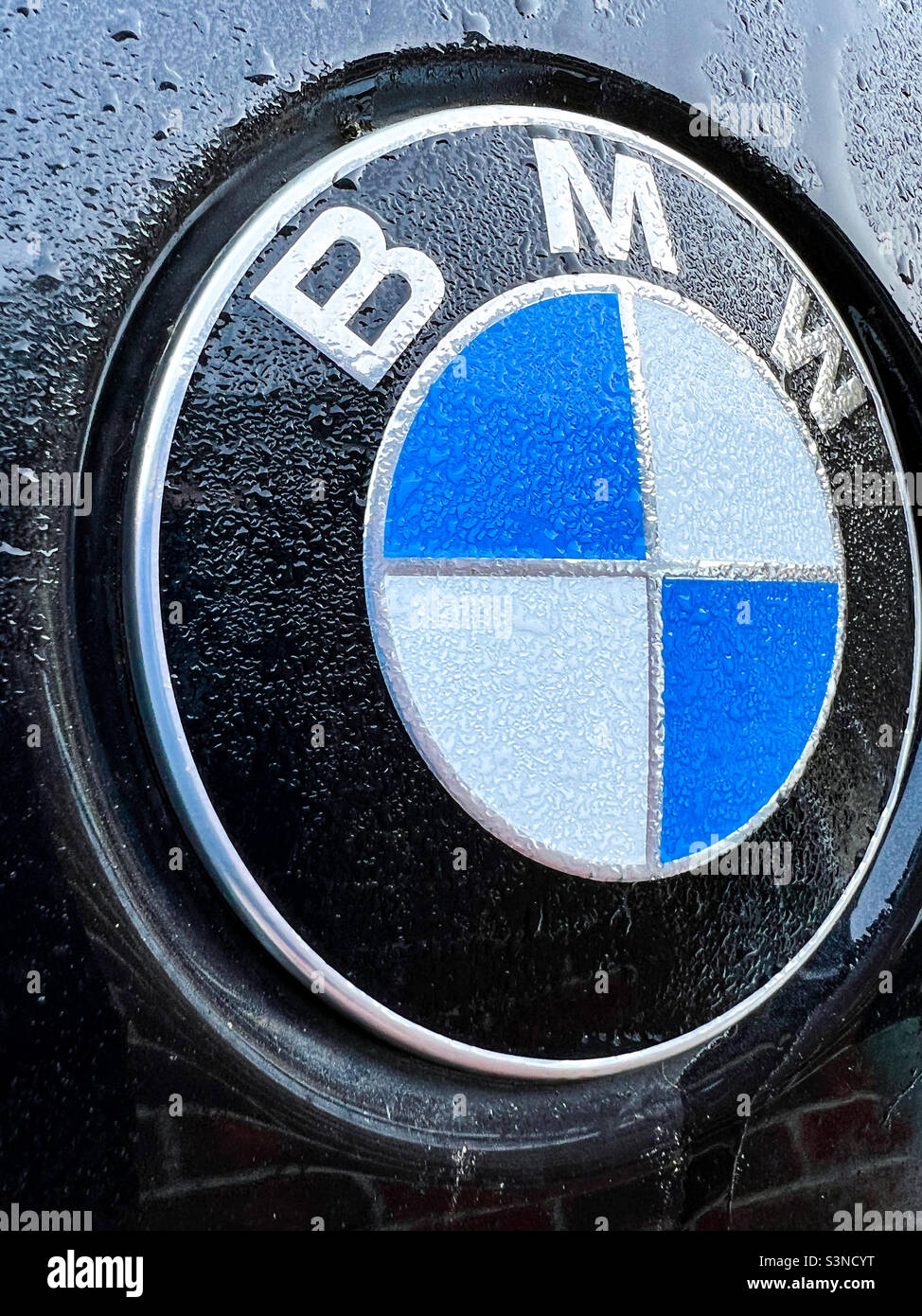 Logo BMW avec rosée tôt le matin et gouttes de pluie - Image de stock capturée avec un smartphone