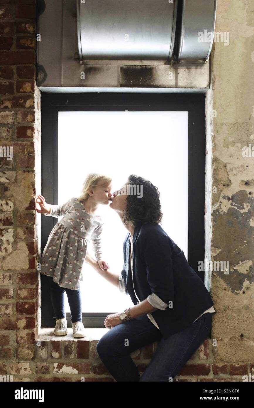 Portrait de mère fille en embrassant la fenêtre Banque D'Images