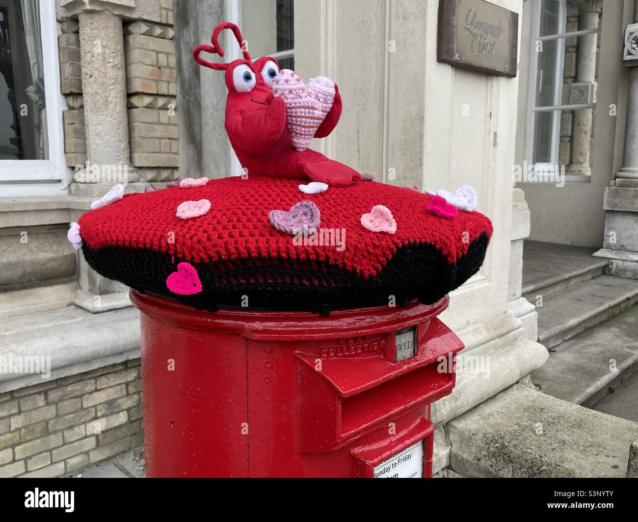 Une boîte pilier britannique portant un bonnet tricoté aux motifs de la Saint-Valentin, vue à Harwich Banque D'Images