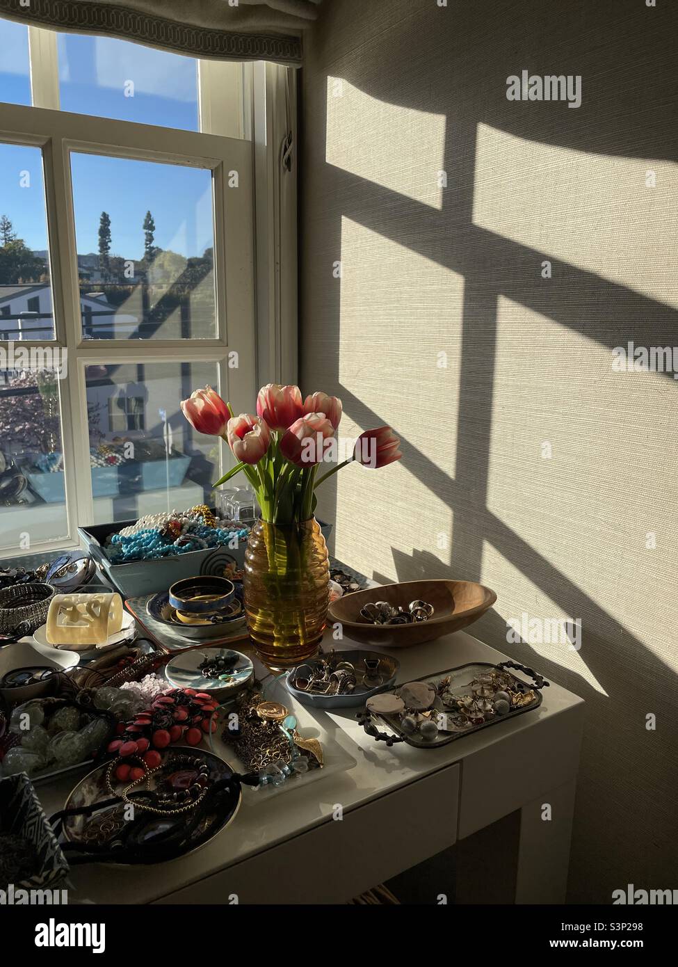 Table à bijoux avec fleurs et vue sur la fenêtre Banque D'Images