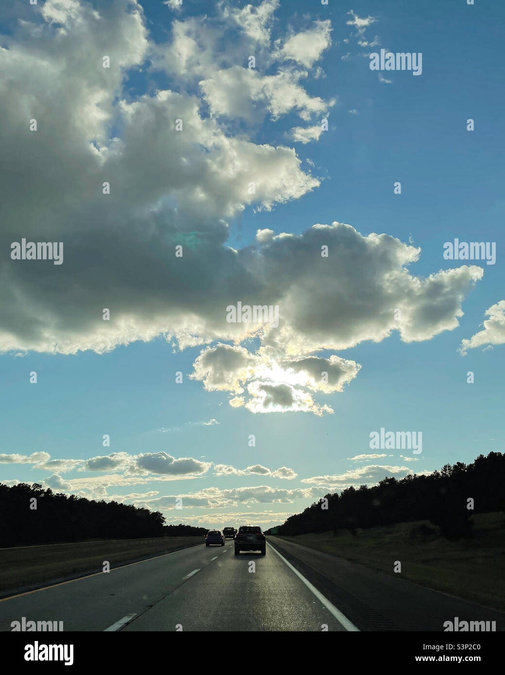 Soleil se cachant derrière un nuage vu de l'autoroute - Image de stock capturée avec un smartphone