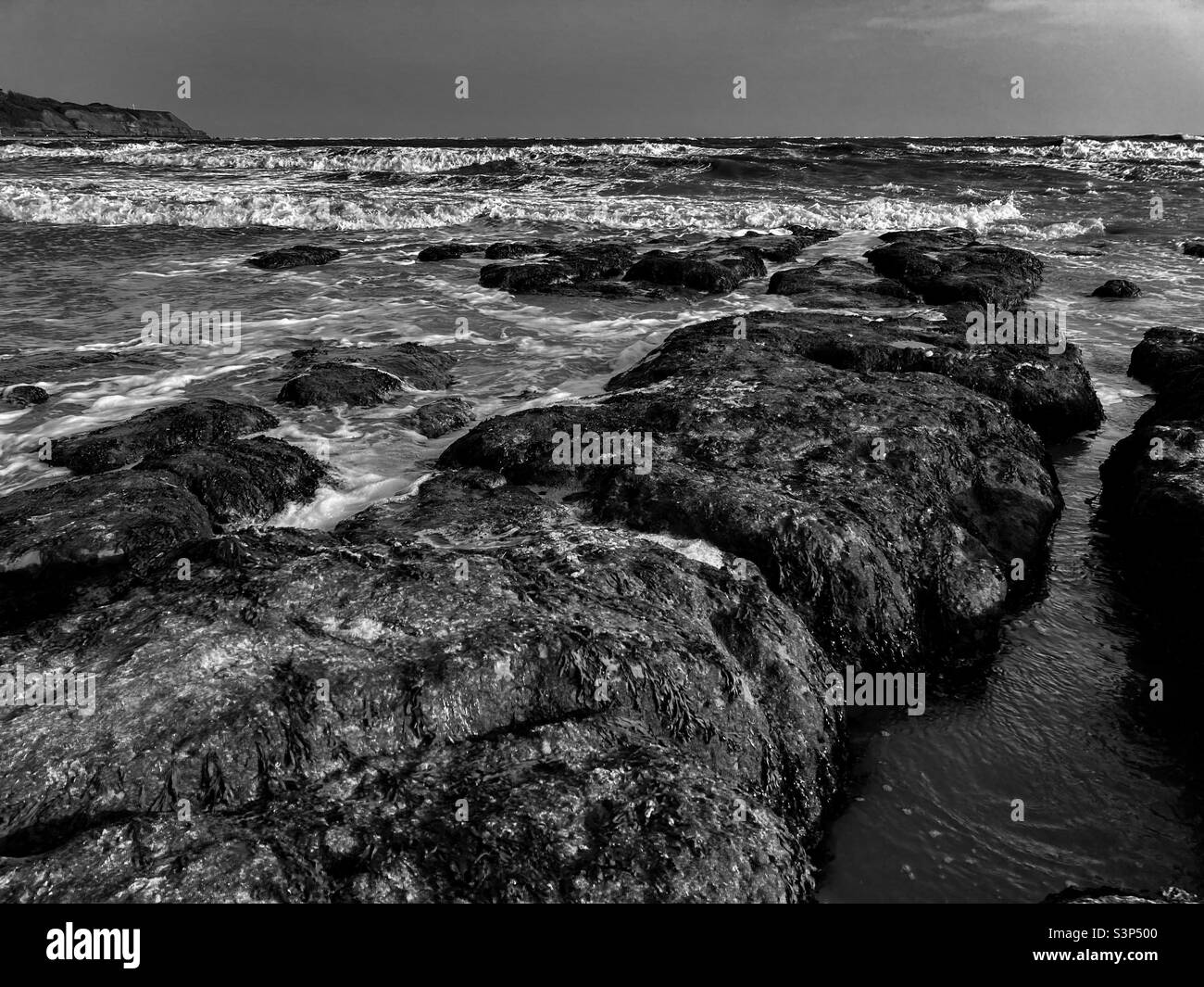 Rochers sur la plage avec la mer de tempête à Exmouth - Image de stock capturée avec un smartphone