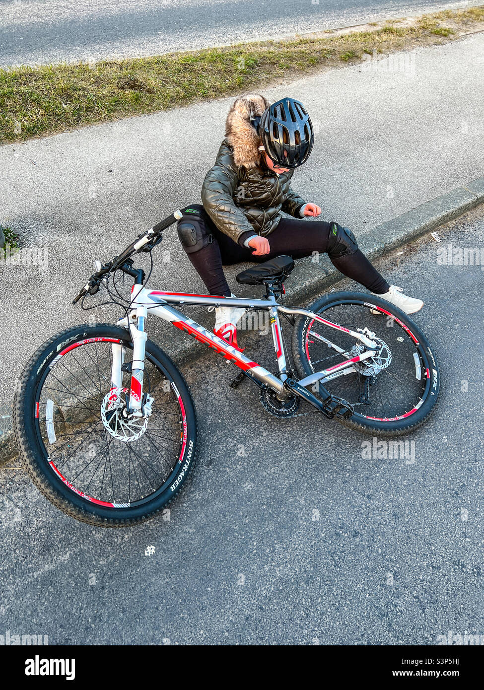 Une jeune fille vient de tomber de son vélo Banque D'Images