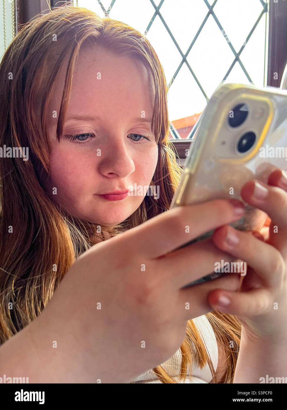 Une jeune fille s'est engagée à jouer avec son iphone Banque D'Images