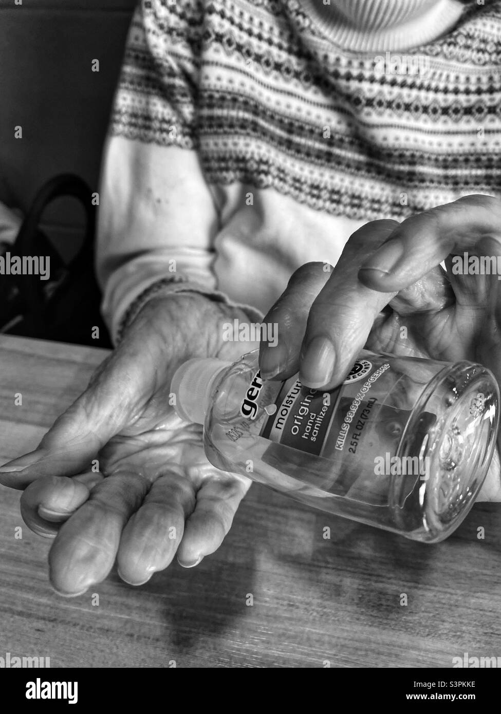 Les mains d'une vieille dame utilisent un désinfectant pour les mains. Banque D'Images