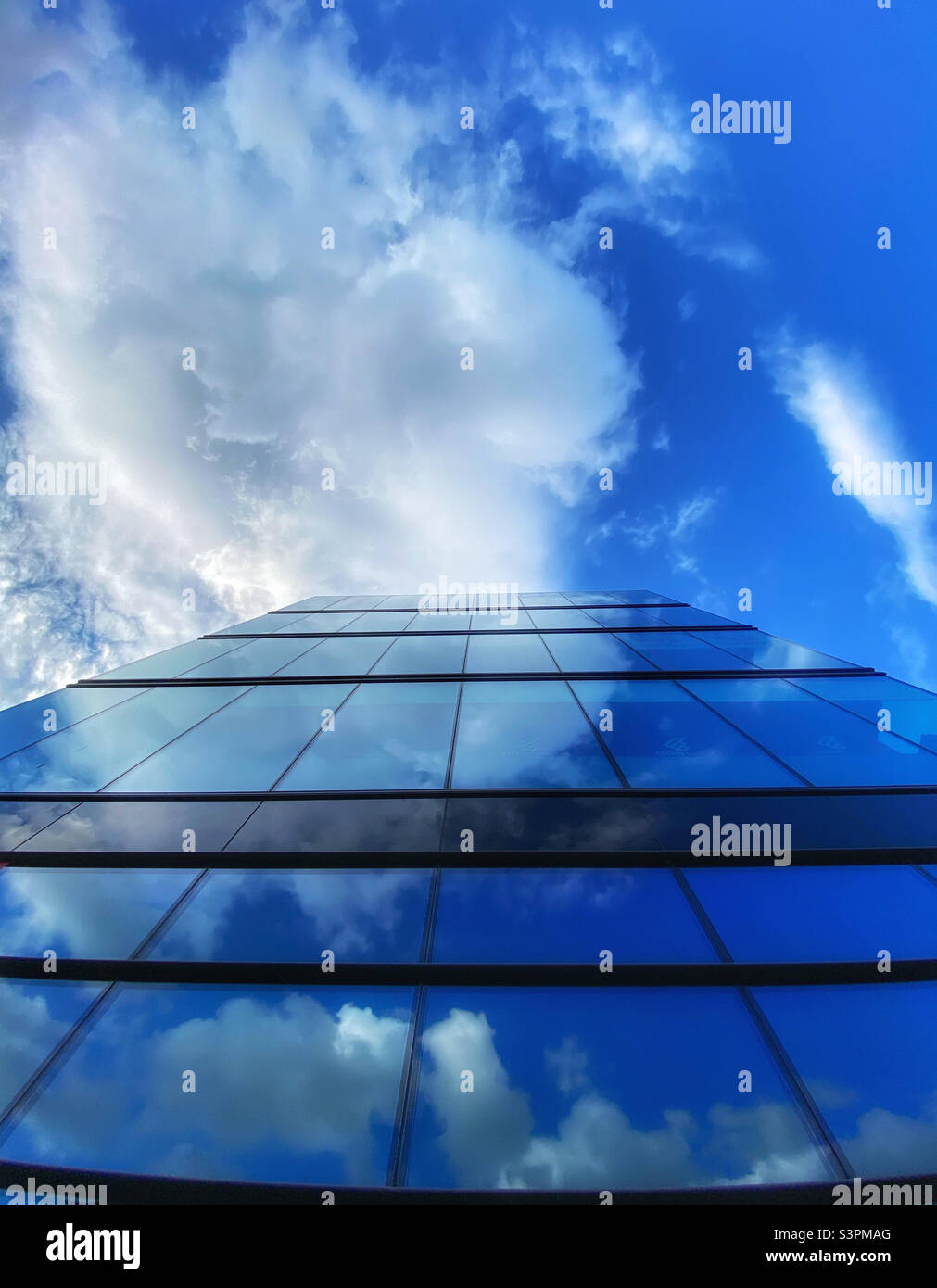 Les nuages se reflètent dans le verre d'un immeuble de bureaux moderne Banque D'Images