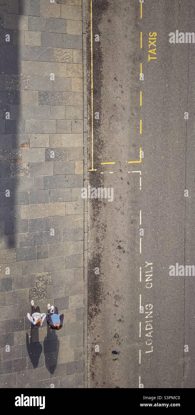 Deux personnes sur la chaussée jetant des ombres d'en haut - Image de stock capturée avec un smartphone