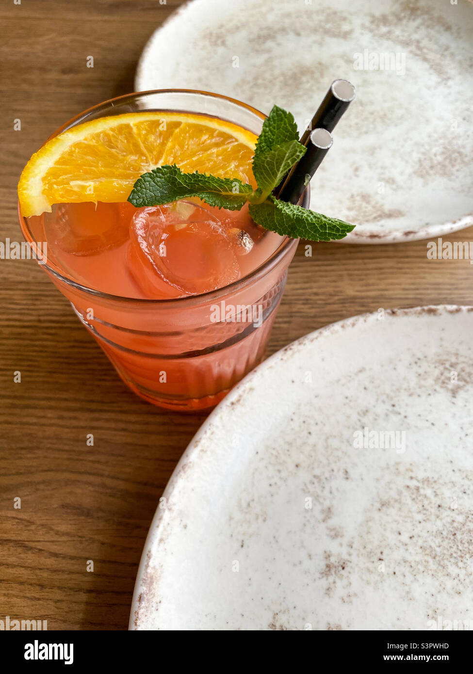 Cocktail de pamplemousse avec une tranche d'orange et de menthe. Cocktail avec glace et pailles Banque D'Images
