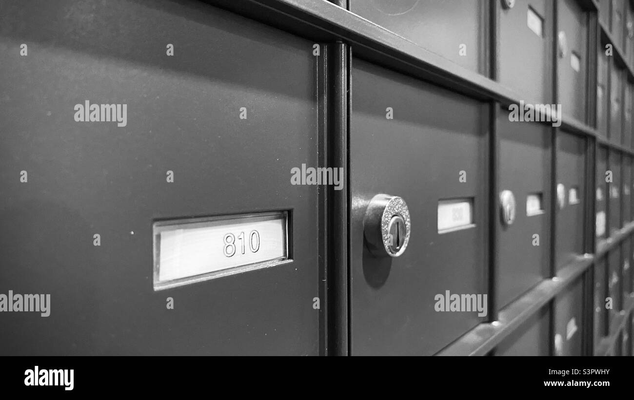 Gros plan sur les boîtes aux lettres verrouillées en mettant l'accent sur le numéro de premier plan. Noir et blanc Banque D'Images