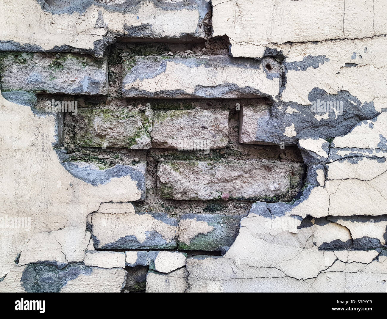 Arrière-plan d'un mur de briques qui s'écroule. La texture d'un mur qui s'émiette Banque D'Images