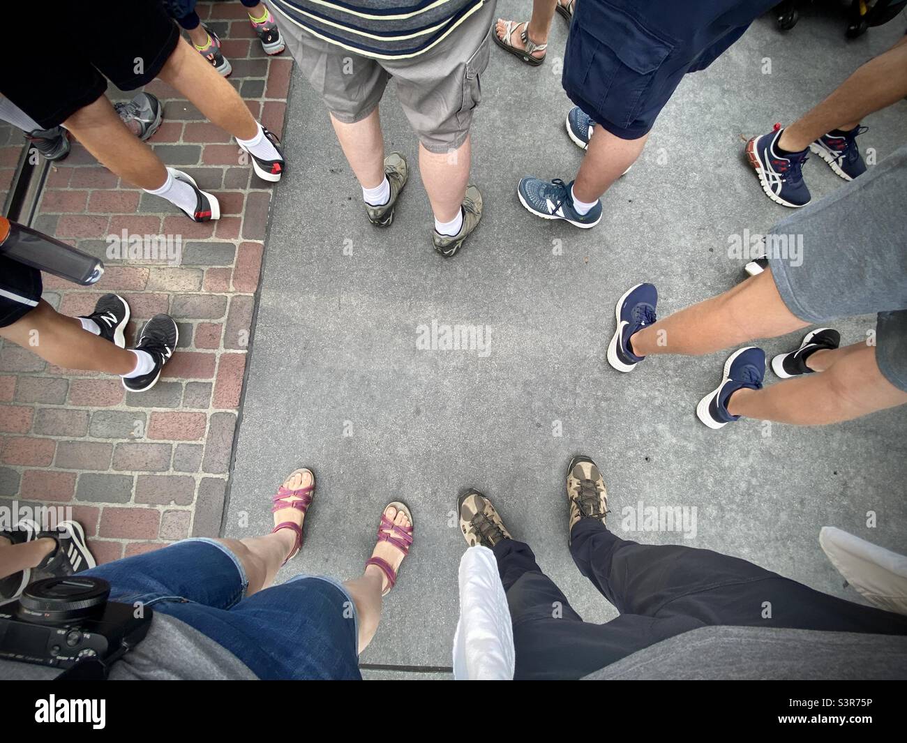 En regardant les jambes et les pieds des gens pendant qu'ils attendent dans la file pour un événement, jour de l'heure Banque D'Images En regardant les jambes et les pieds des gens pendant qu'ils attendent dans la file pour un événement, jour de l'heure Banque D'Images