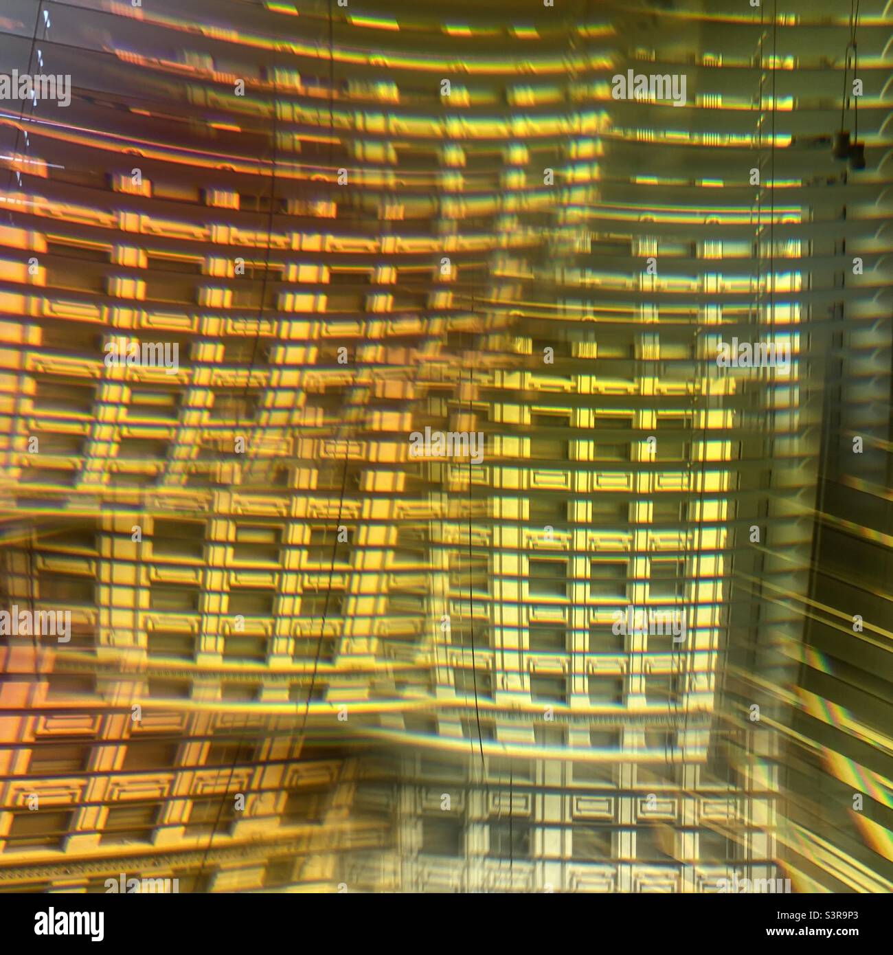 Motif abstrait coloré créé avec prisme devant l'objectif de l'appareil photo. Façade d'un bâtiment historique vu comme de multiples images composiées à travers la fenêtre avec des stores vénitiens Banque D'Images