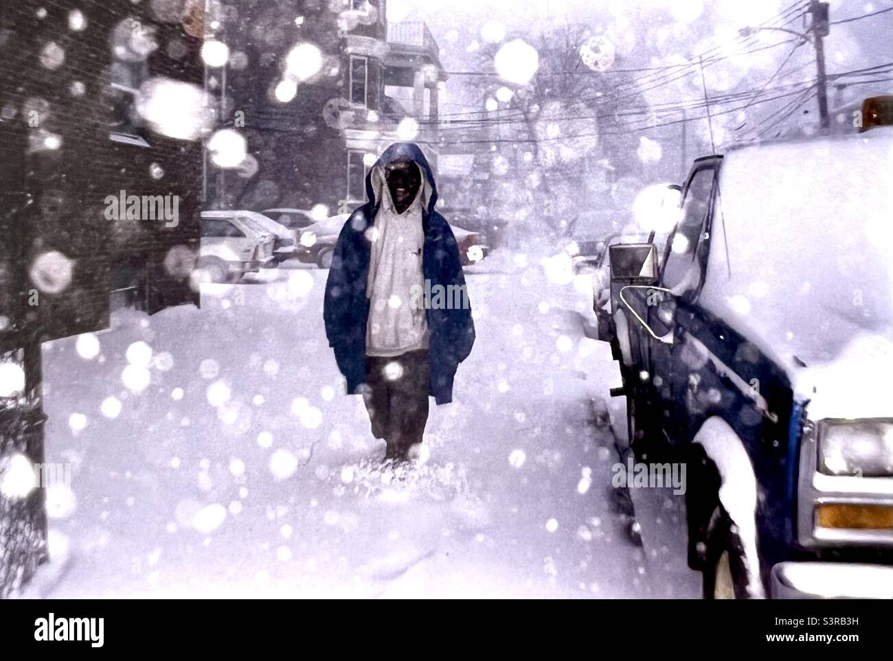 Homme marchant sur Boston Street pendant un blizzard avec de la neige au-dessus de ses chevilles Banque D'Images
