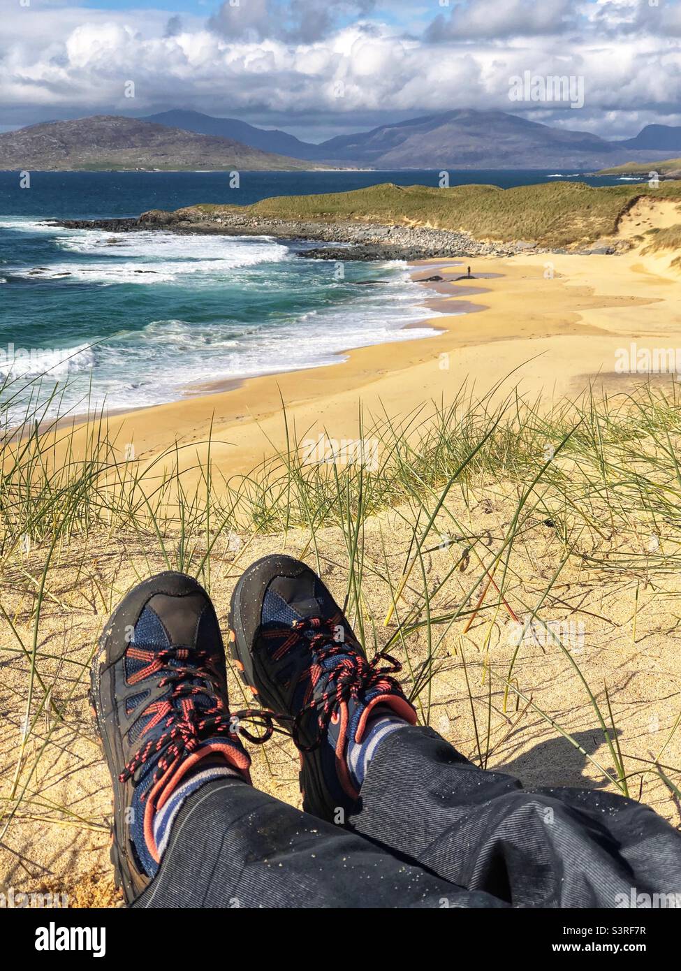 Assis dans les dunes de sable à Traigh Mhor Borve, plage de sable sur l'île de Harris, en Écosse - Image de stock capturée avec un smartphone