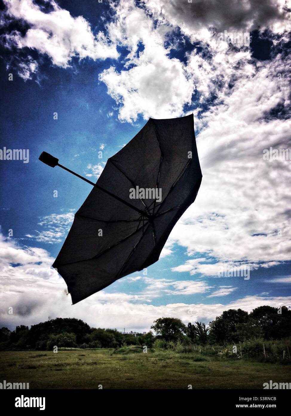 Un parapluie noir en plein air qui a été soufflé par le vent Banque D'Images