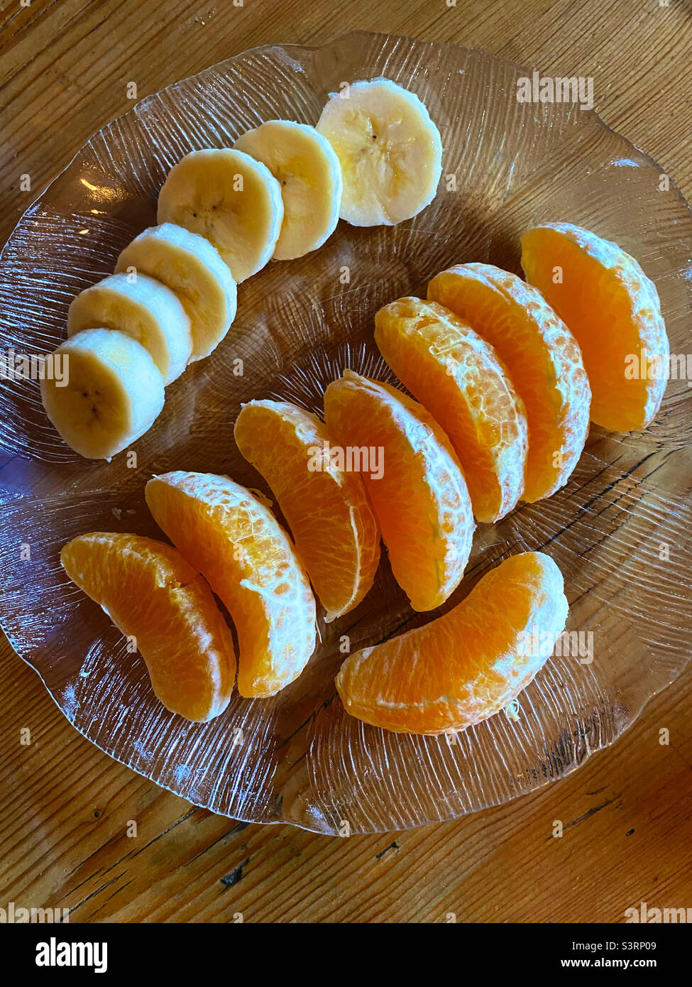 Tranches d'orange et de banane fraîches sur une plaque en verre transparent - Image de stock capturée avec un smartphone