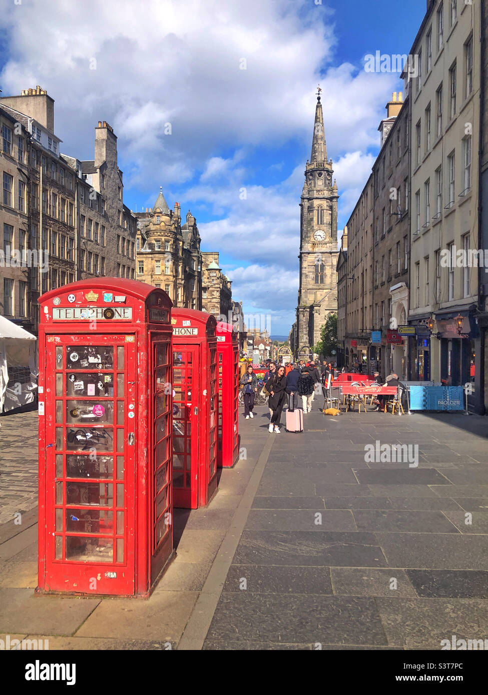 Royal Mile, Édimbourg, Écosse, avec trois stands emblématiques de téléphone rouge en premier plan et le Tron Kirk en arrière-plan. Banque D'Images