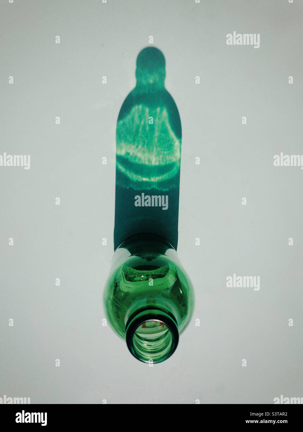 Ombre d'une bouteille verte sur fond simple Banque D'Images