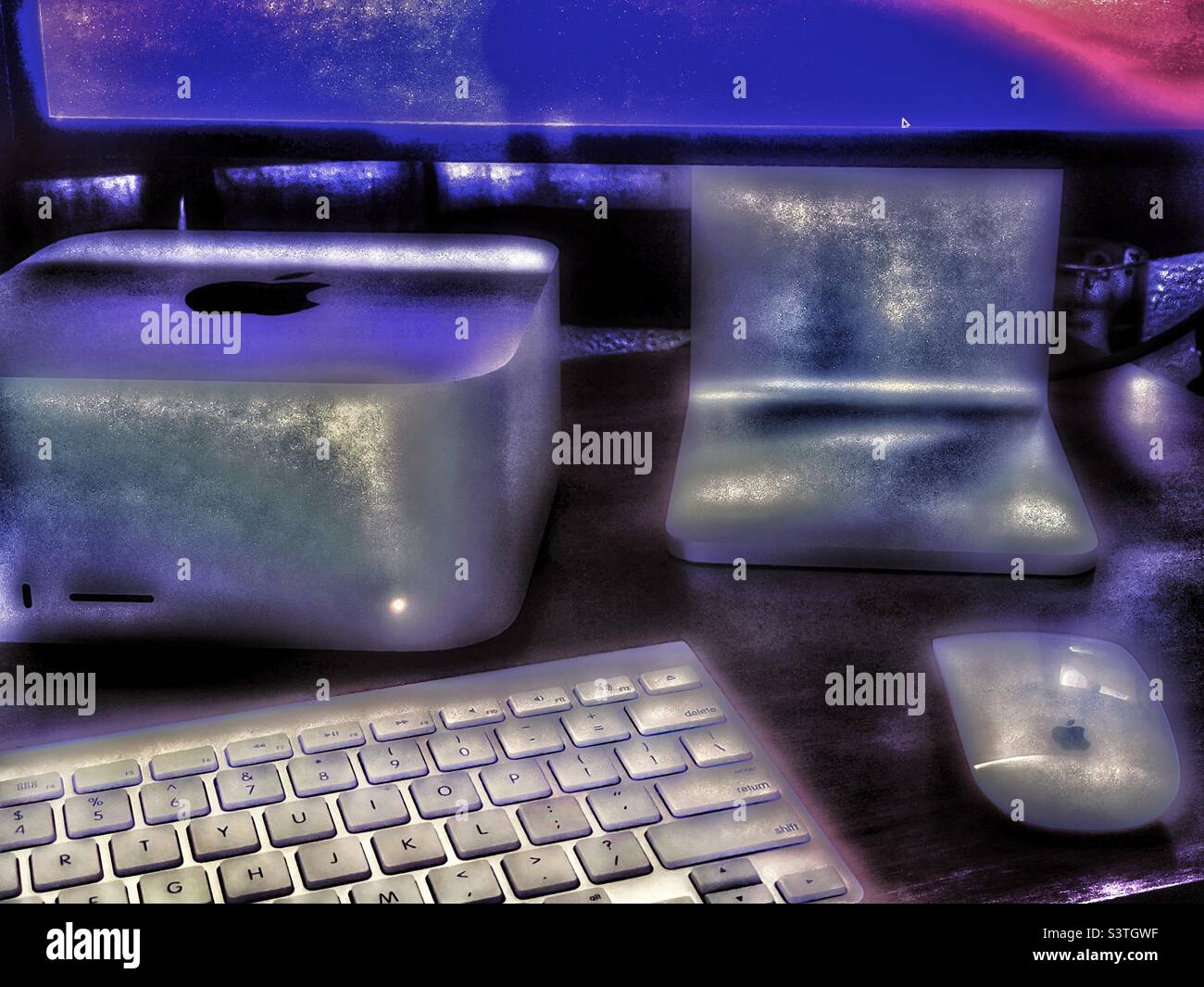 Le nouvel ordinateur Mac Studio Apple installé sur un bureau dans un bureau à domicile dans l'Utah, aux États-Unis. Effets lumineux et grunge ajoutés numériquement. - Image de stock capturée avec un smartphone