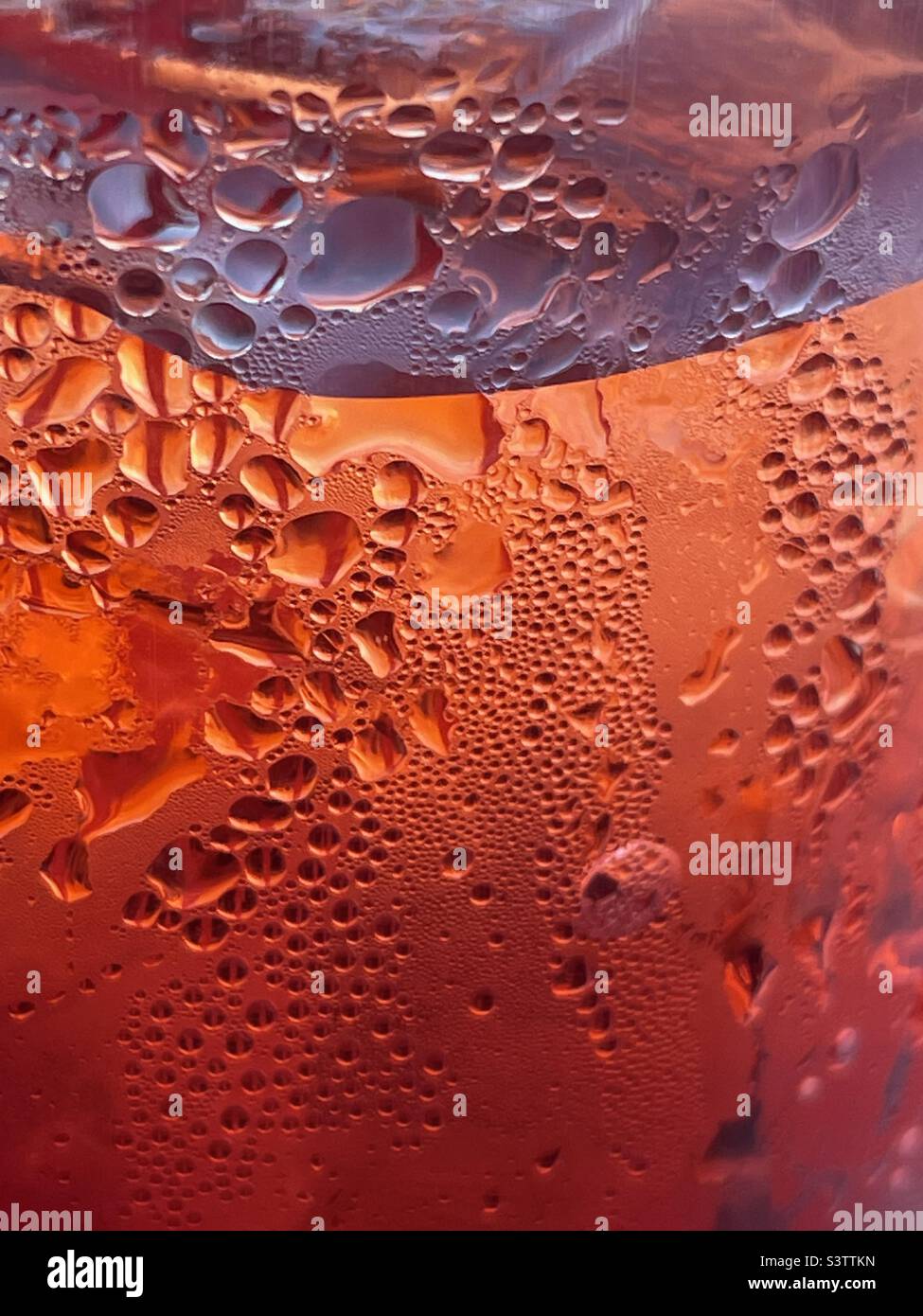 Une grande tasse de sprite de cerise froide glacée. Le froid, rouge, le liquide carbonaté, la glace et la condensation sur la tasse font un grand résumé rafraîchissant. Banque D'Images