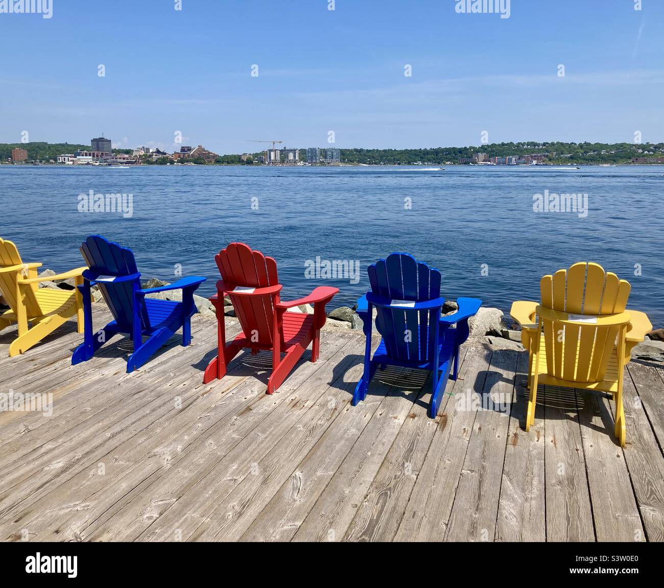 Des chaises classiques de Muskoka donnent sur Halifax Bay avec Dartmouth au loin. Banque D'Images