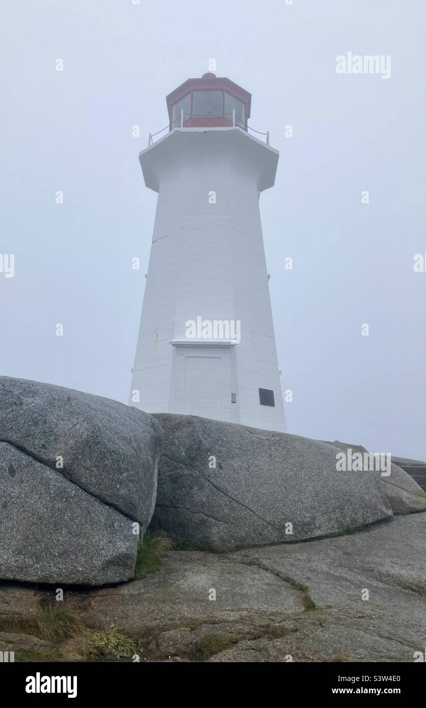 Vue latérale du phare de Peggy's Cove dans un brouillard épais. Banque D'Images