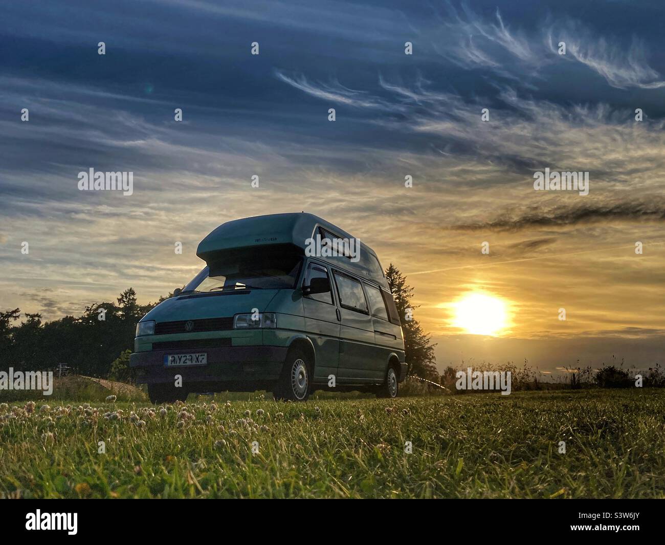 Fourgonnette VW Camper dans un camping au coucher du soleil dans Northumberland Banque D'Images