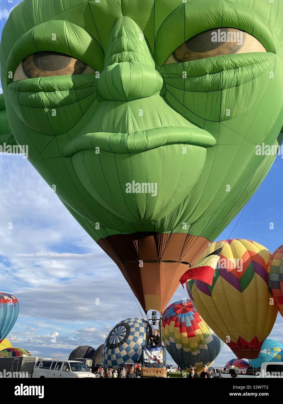 Ballon d'air chaud vert extraterrestre gonflé sur un champ prêt à être lancé. Banque D'Images