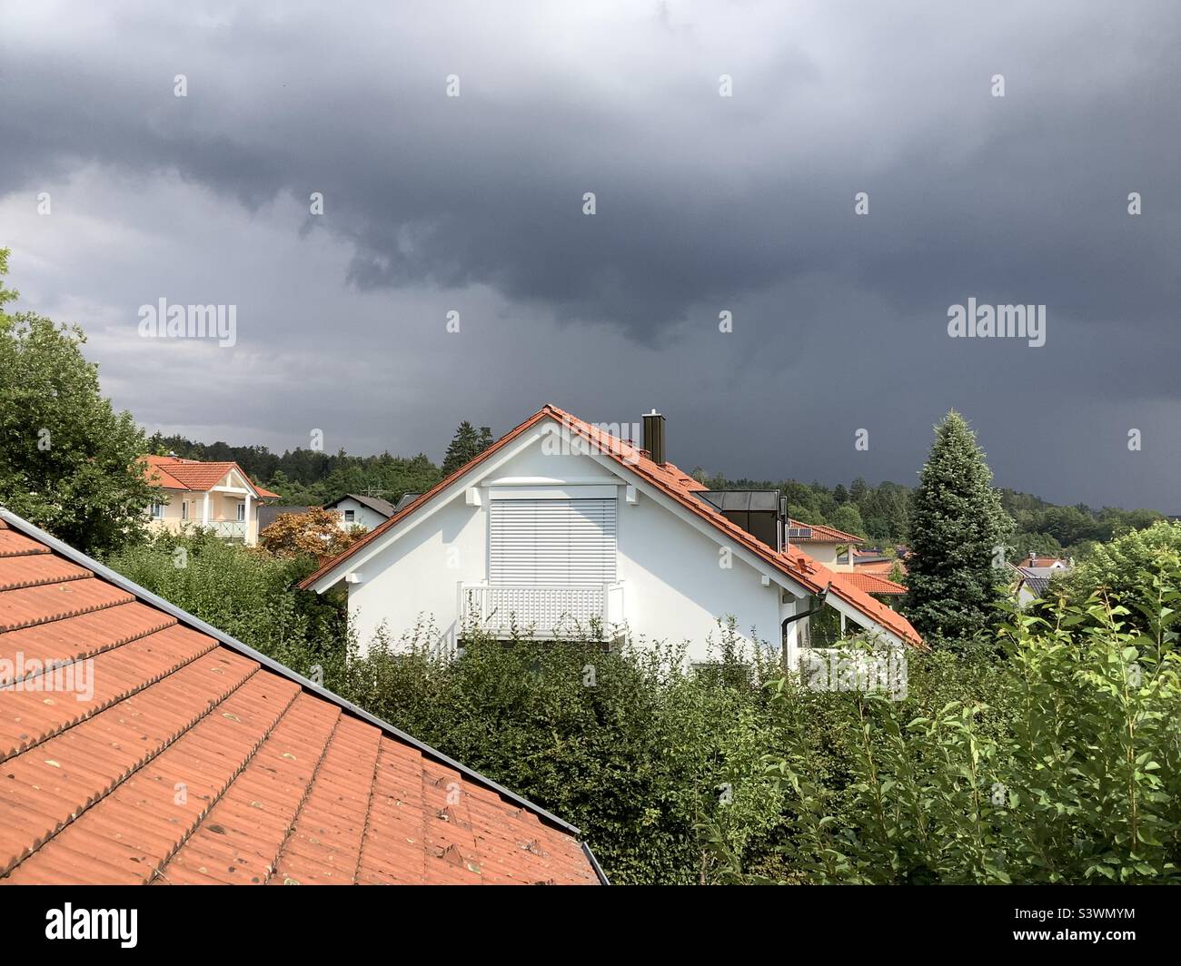 Des pluies sombres et des nuages de tempête au-dessus d'un règlement avec des maisons unifamiliales Banque D'Images