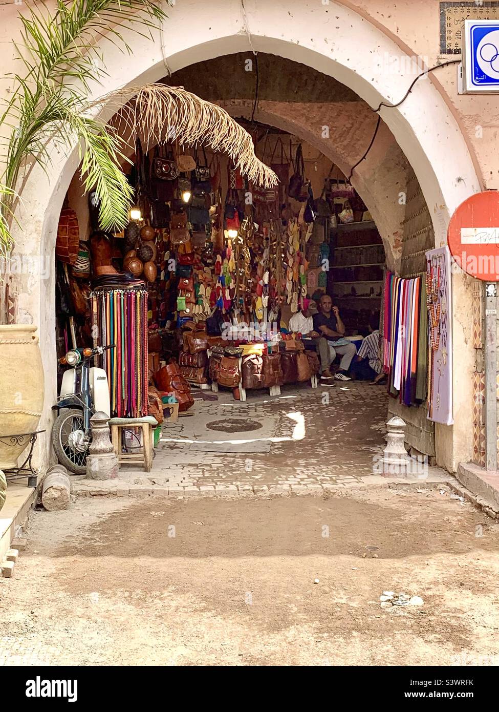 Articles de cuir en vente sous une arcades dans les Souks, Marrakech, Afrique du Nord. Banque D'Images