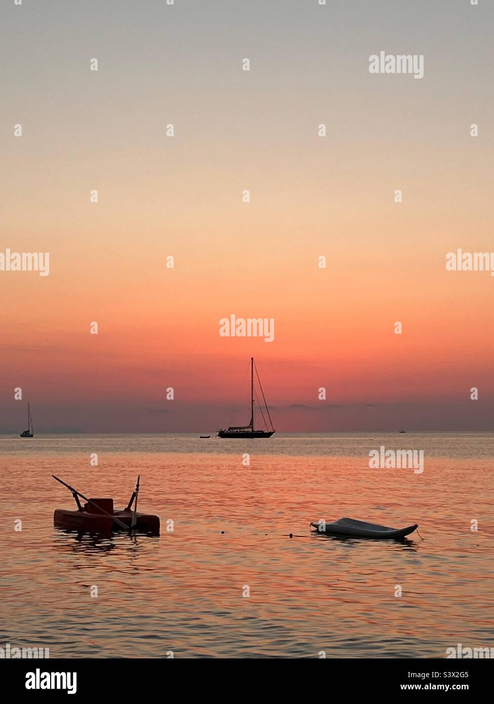 Bateaux et un yacht ancré à Cefalù, Sicile Italie au coucher du soleil Banque D'Images