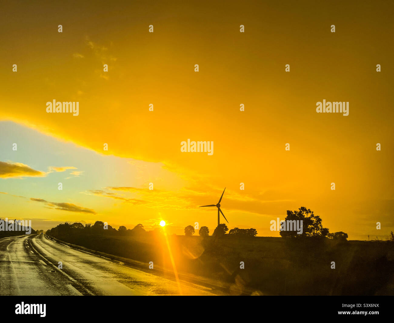 Coucher de soleil orange vif sur une route de campagne dans East Riding of Yorkshire Banque D'Images