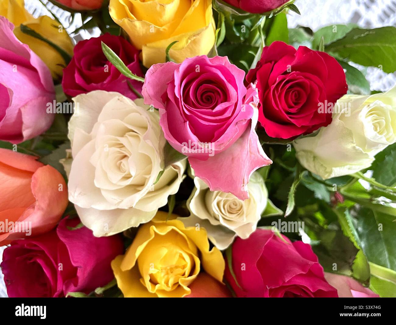 Un bouquet de roses. Photo prise d'en haut, toile de table en crochet derrière. Banque D'Images