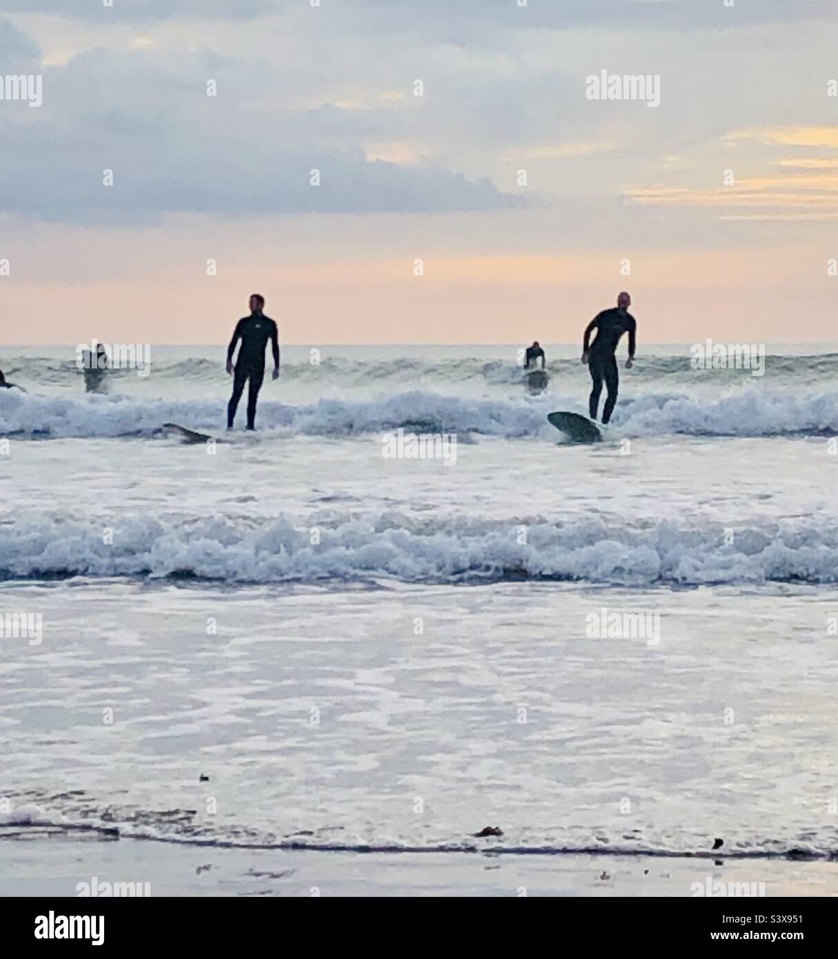 Les surfeurs surfent sur les vagues à Saunton Sands, dans le Devon, en Angleterre Banque D'Images